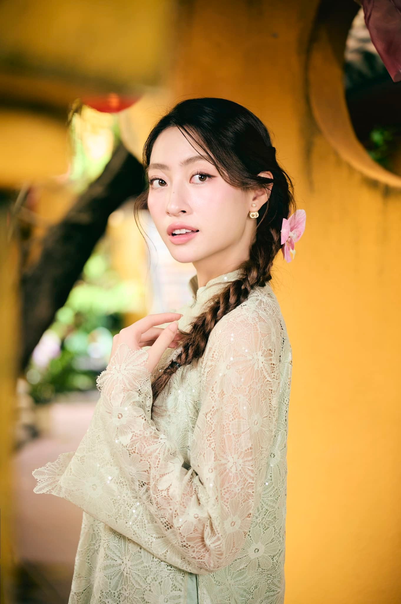 Hoa hậu Lương Thùy Linh mặc áo dài ren màu xanh đi vãn cảnh chùa ở quê hương Cao Bằng trong ngày Mùng 3 Tết.