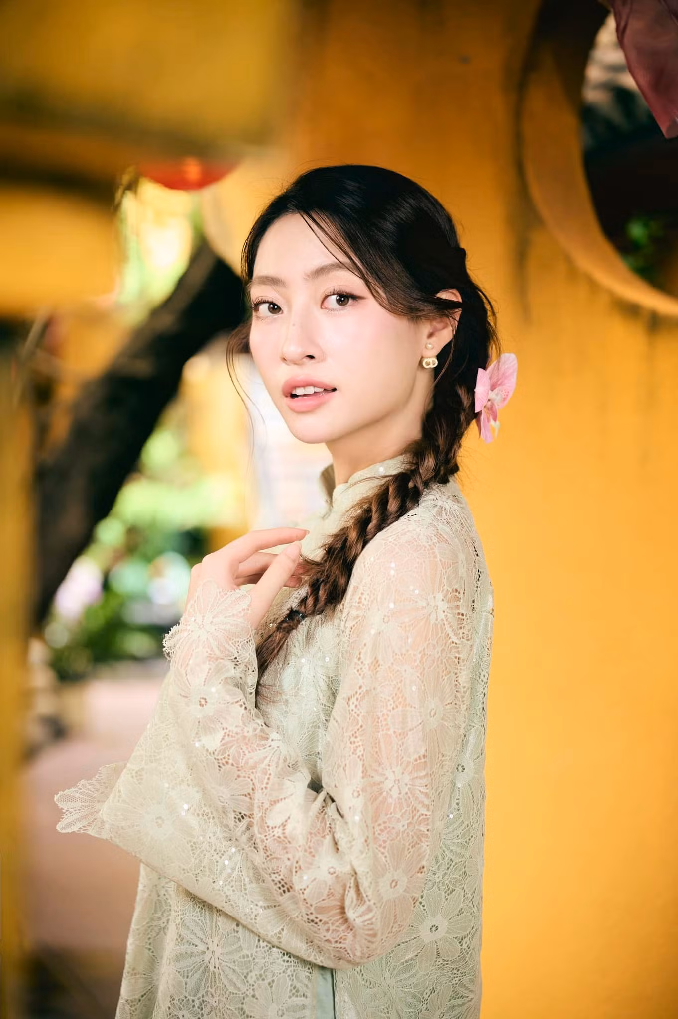 Hoa hậu Lương Thùy Linh mặc áo dài ren màu xanh đi vãn cảnh chùa ở quê hương Cao Bằng trong ngày Mùng 3 Tết.