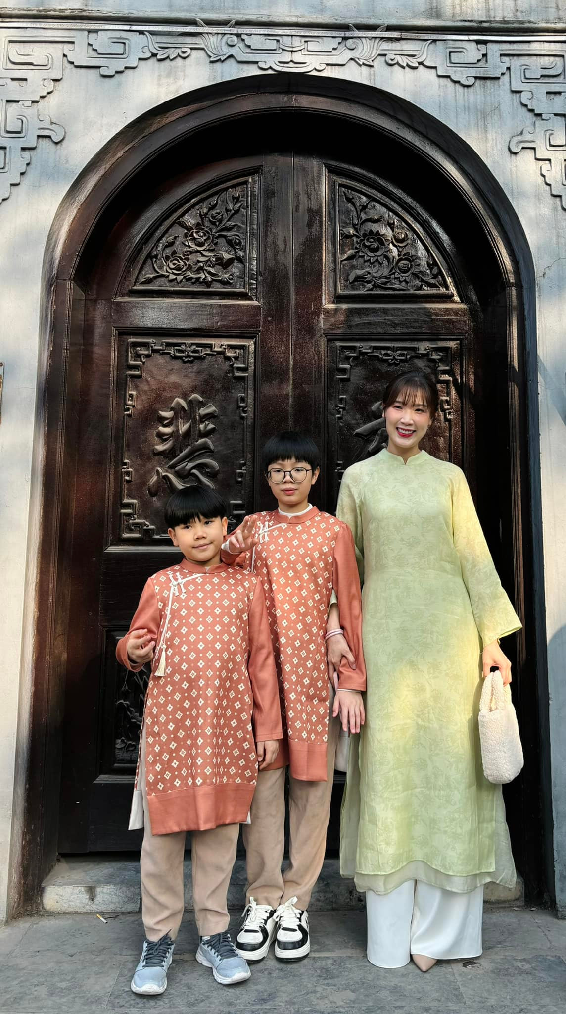 Hoa hậu Áo dài Phí Thùy Linh mặc áo dài xanh nền nã, đưa các con đi chúc Tết họ hàng.