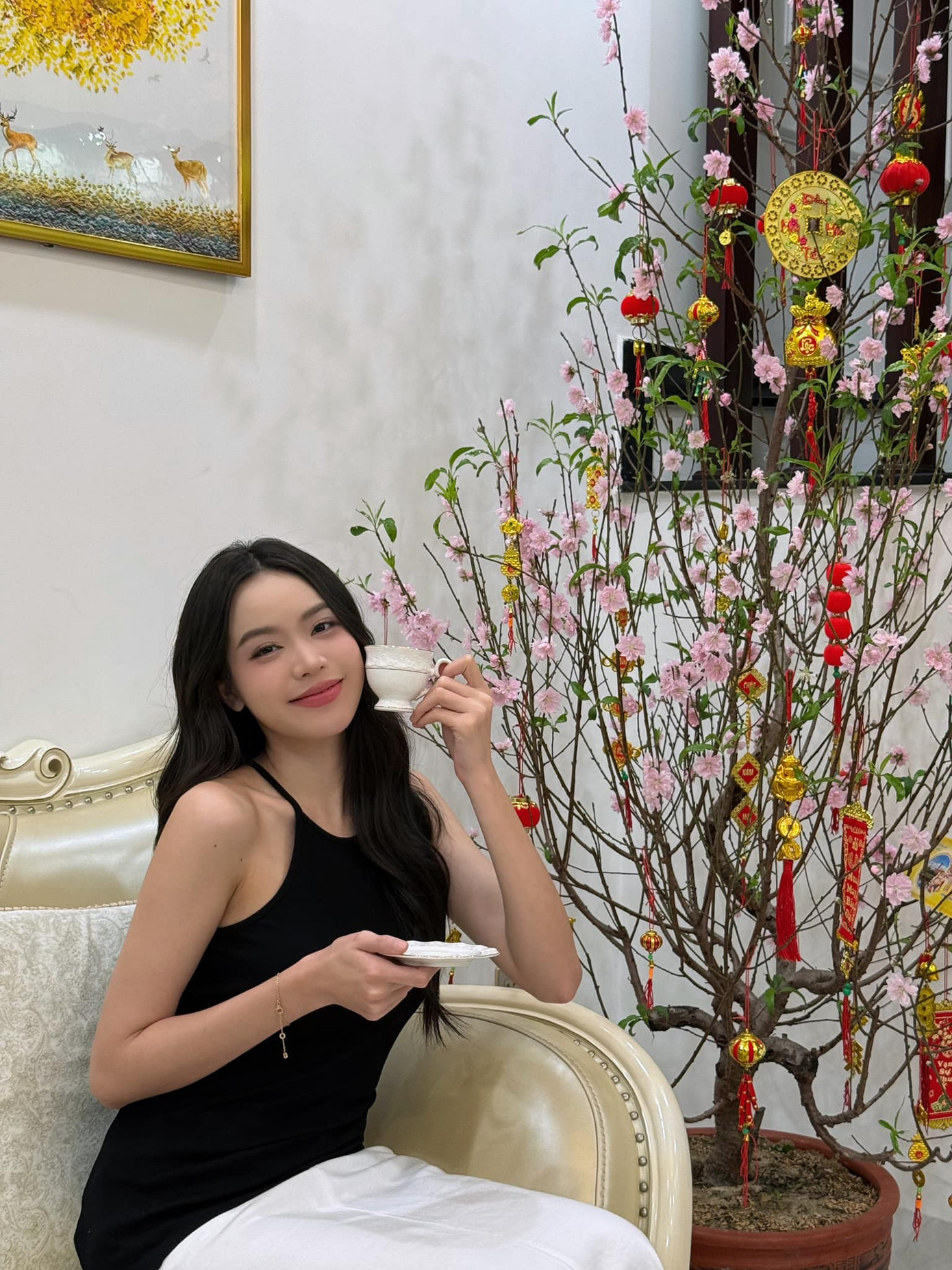 Hoa hậu Thanh Thủy khoe nhan sắc dịu dàng khi khoe sắc bên hoa đào trong nhà ngày Mùng 3 Tết.