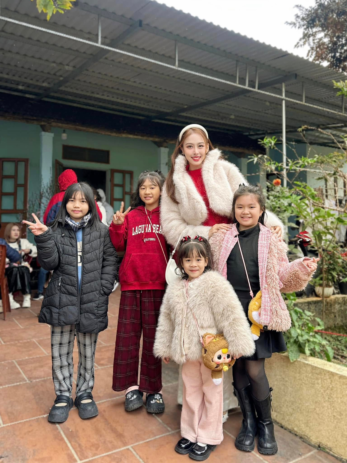 Á hậu Ngọc Hằng mặc áo dài đỏ khi đi chúc Tết họ hàng trong ngày mùng 1 Tết.