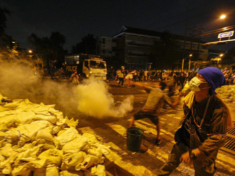 Người biểu tình ném trả lựu đạn cay vào cảnh sát. ẢNH: TODAY ONLINE. Người biểu tình ném trả lựu đạn cay vào cảnh sát . ẢNH: TODAY ONLINE