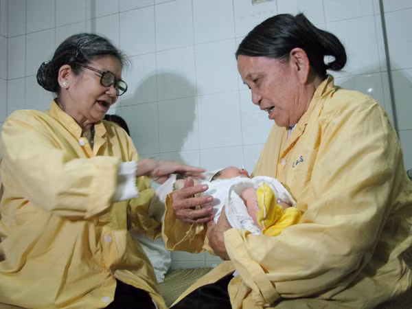 Sáng nay, bà Vũ Thị Quyết(phải)bắt con cháu chở từ Hưng Yên lên Hà Nội để xem mặt và bế cháu nội. 
