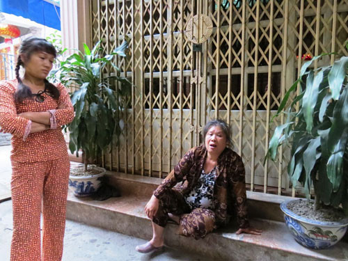 Bà Vũ Thị Thanh (chị dâu ông Quý) ngồi thẫn thờ trước hiên nhà em chồng. Ảnh: Giang Chinh