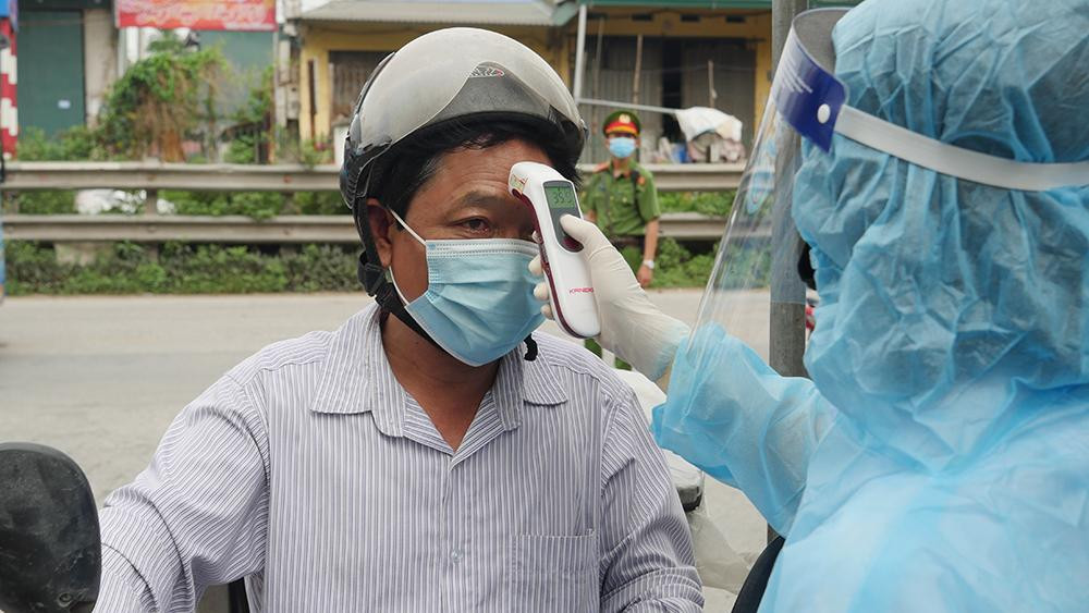 Lực lượng y tế đo thân nhiệt người trở về địa phương.