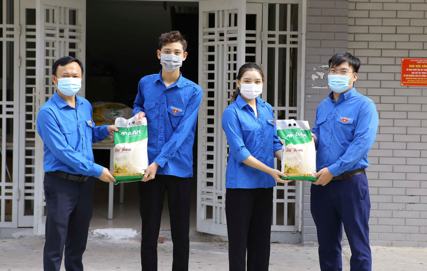 Anh Phạm Tuấn Anh, Uỷ viên BCH T.Ư Đoàn, Bí thư Đoàn Thanh niên Báo Tiền Phong (ngoài cùng bên trái) và anh Bùi Văn Dự, Phó Bí thư thường trực Đoàn Thanh niên Học viện Thanh Thiếu niên Việt Nam (ngoài cùng bên phải) trao tặng quà cho sinh viên.