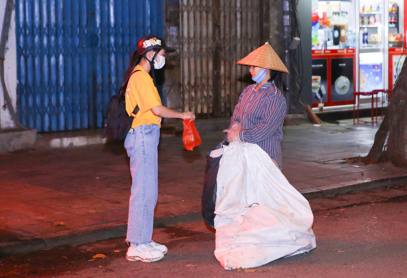 Bạn Phùng Thị Hiền tặng quà cho người vô gia cư khu vực bệnh viện Việt Đức.