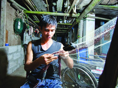 Bị liệt nửa người, anh Huệ dùng đôi tay khéo léo để dệt lưới bán và giăng câu. Bị liệt nửa người, anh Huệ dùng đôi tay khéo léo để dệt lưới bán và giăng câu