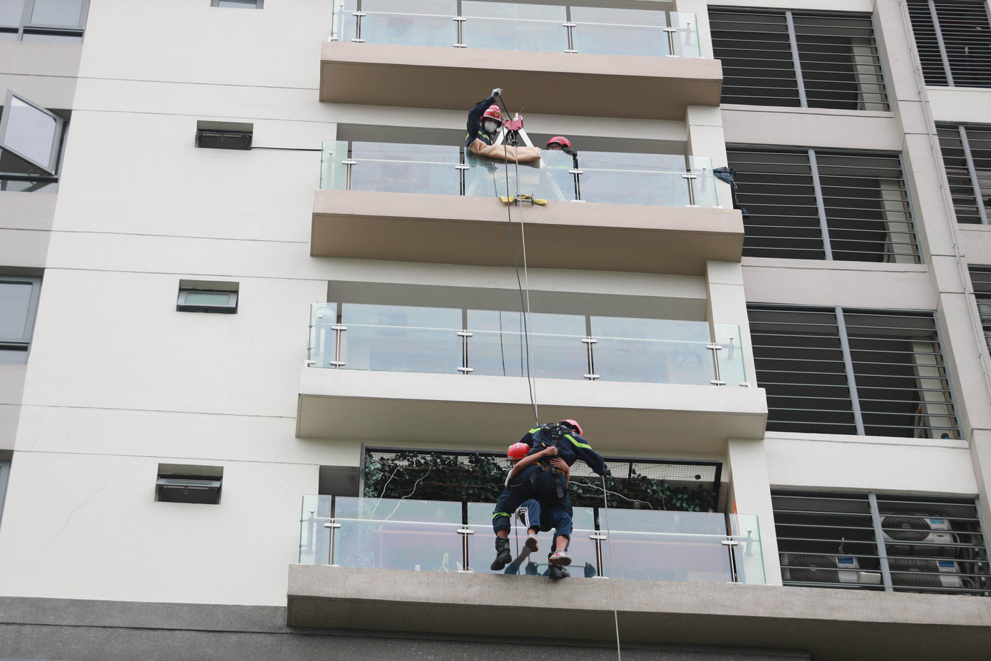 Trong khi đó, những người mắc kẹt trên các tầng cao được cảnh sát sử dụng ròng rọc đu dây đưa xuống đất an toàn.