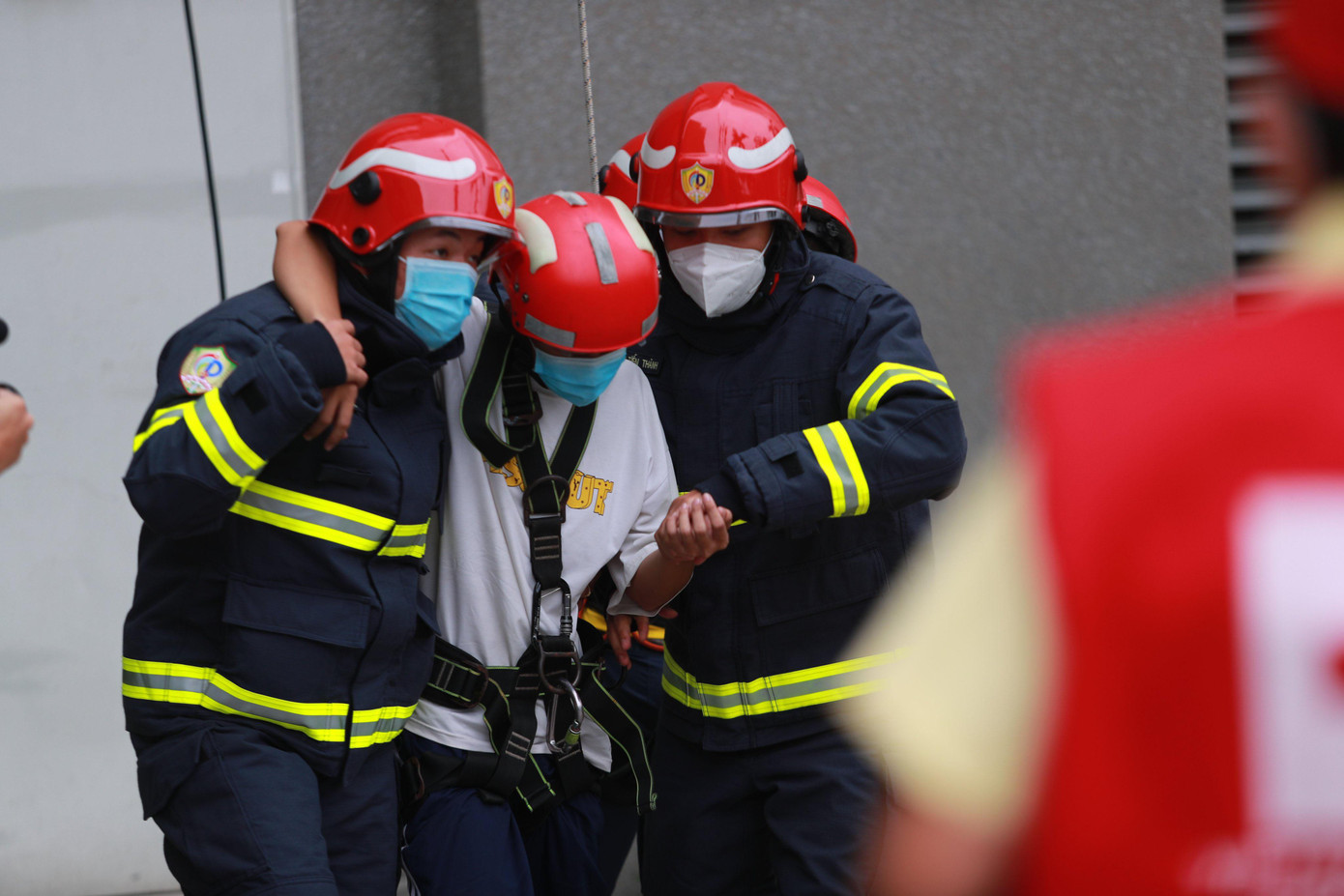 Những người bị thương do vụ cháy được lính cứu hỏa hỗ trợ đưa ra ngoài để lực lượng y tế chăm sóc.