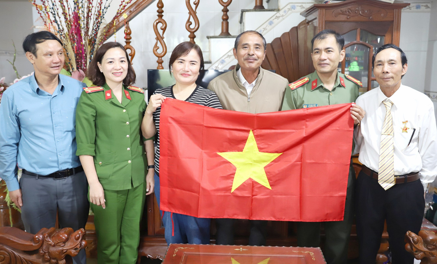 Lực lượng công an đến nhà dân trao tặng cờ Tổ quốc