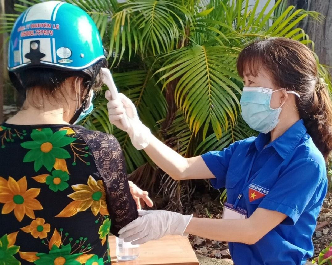 Tình nguyện viên đo thân nhiệt cử tri đi bầu cử Tình nguyện viên đo thân nhiệt cử tri đi bầu cử