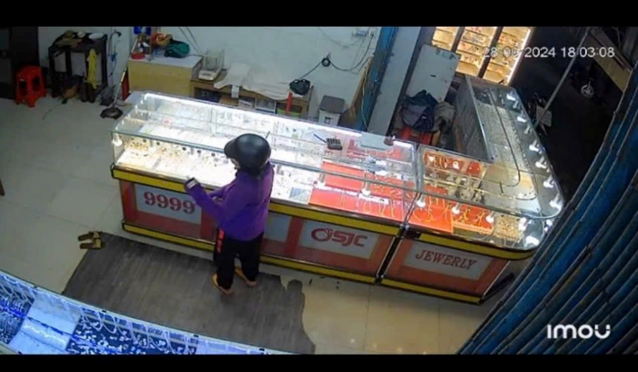 Người phụ nữ mặc áo tím, trùm kín mặt đến tiệm vàng hỏi mua vàng