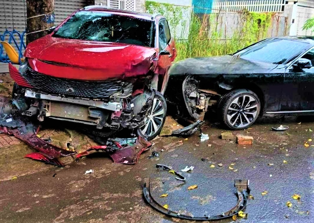 Chiếc xe màu đỏ bị tông, hư hỏng nặng