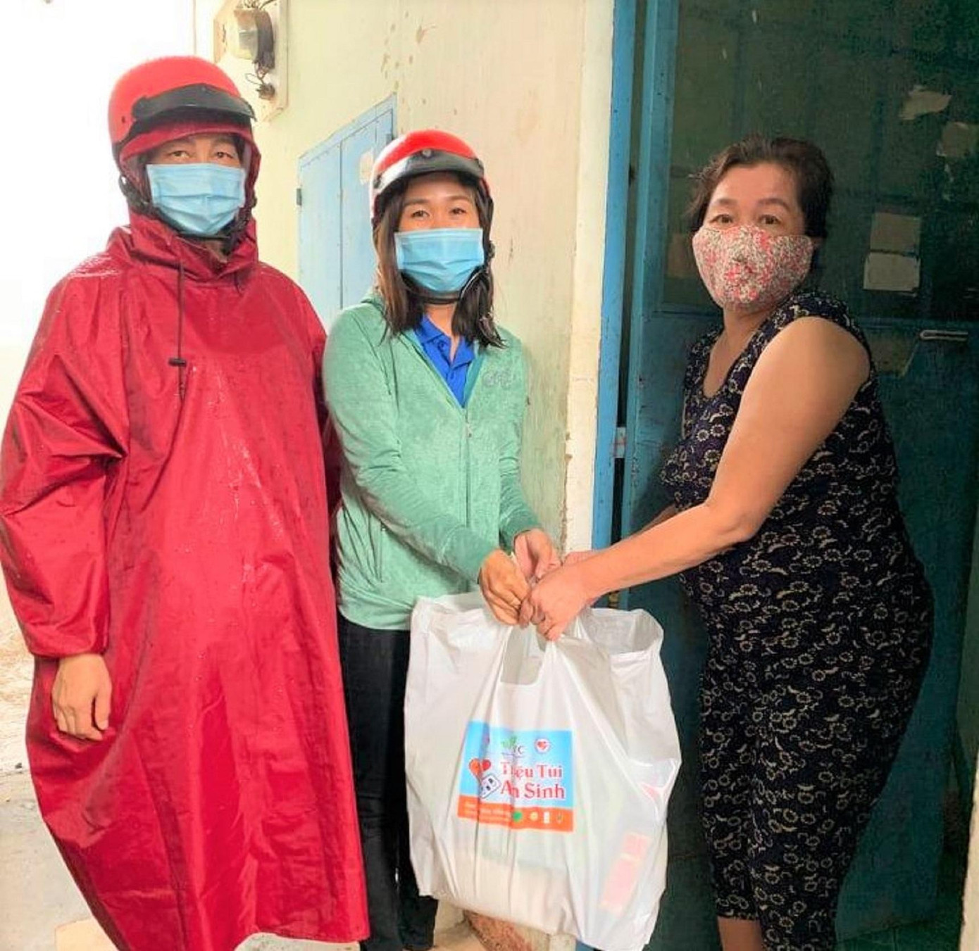 Tình nguyện viên đội mưa mang quà đến cho người dân