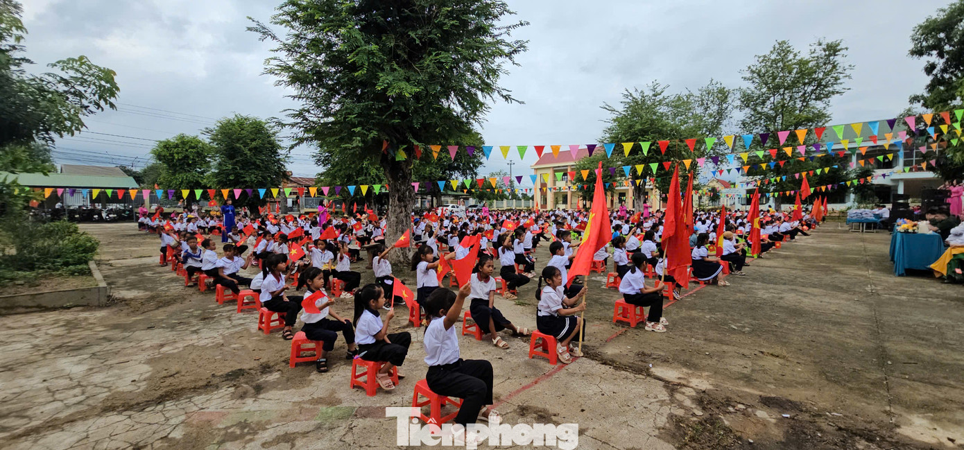Các em học sinh vẫy cờ chào đón năm học mới