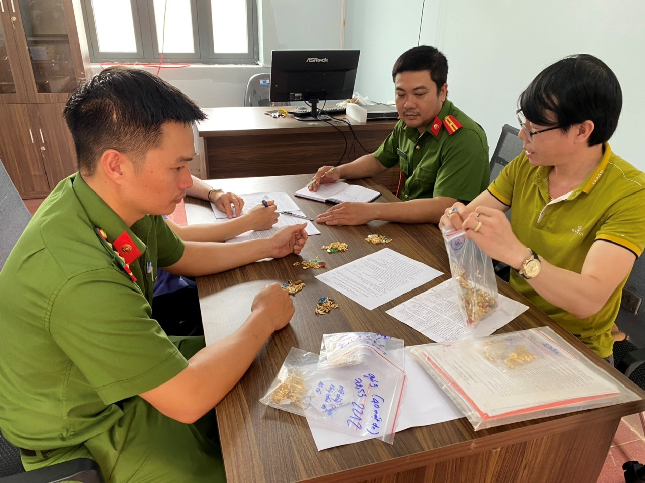 Lực lượng chức năng cùng bị hại kiểm đếm lại số vàng