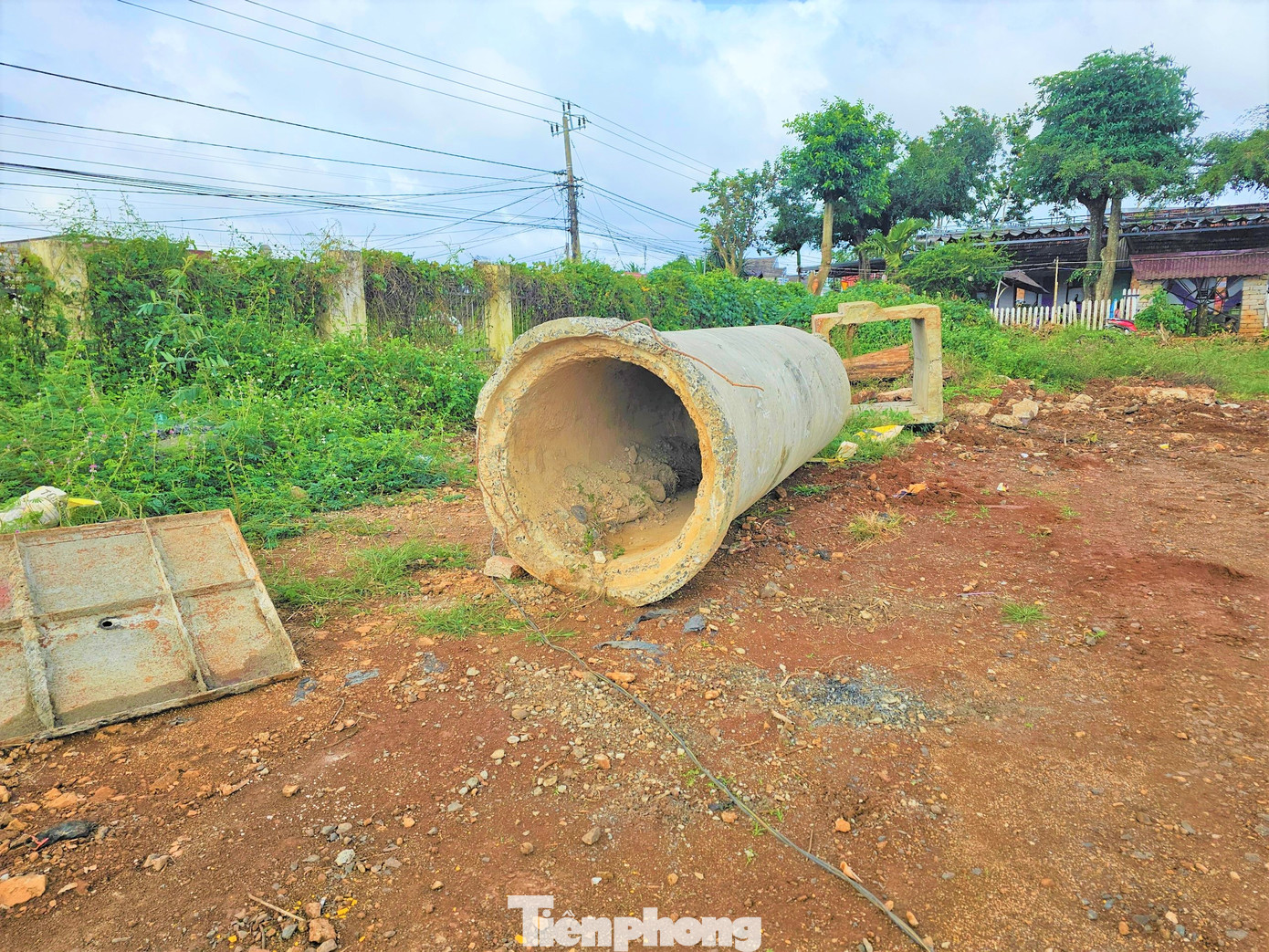 Một ống bê tông kích thước lớn được vứt lăn lóc trong sân.