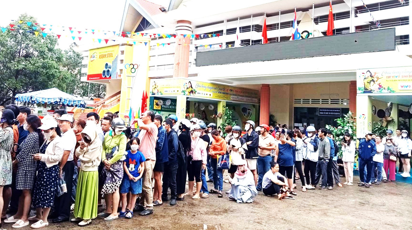 Có người ngồi bệt xuống đất trong lúc chờ tới lượt được mua vé Có người ngồi bệt xuống đất trong lúc chờ tới lượt được mua vé