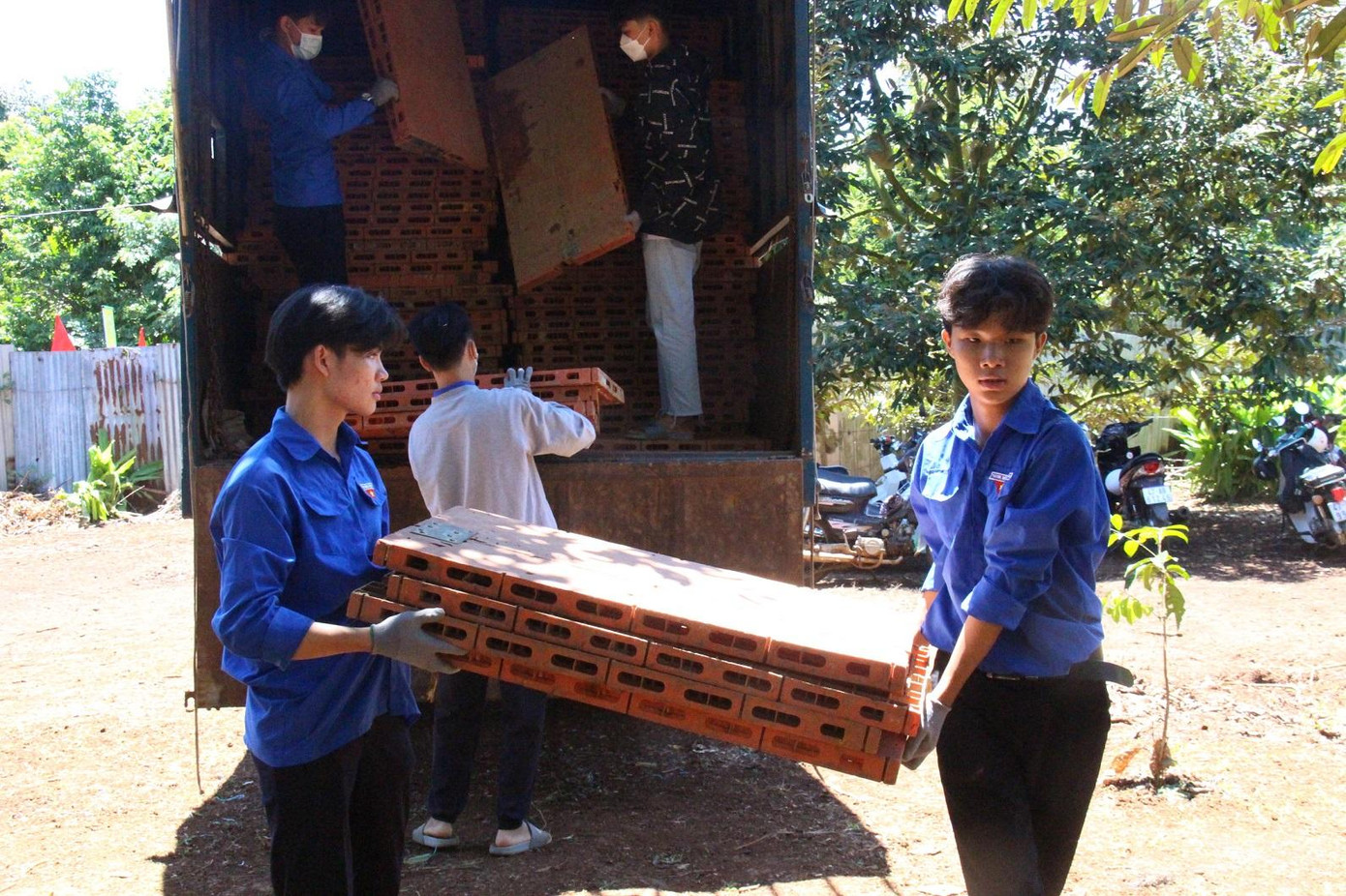 Các bạn đoàn viên bê các tấm lót trải tại các vườn sầu riêng