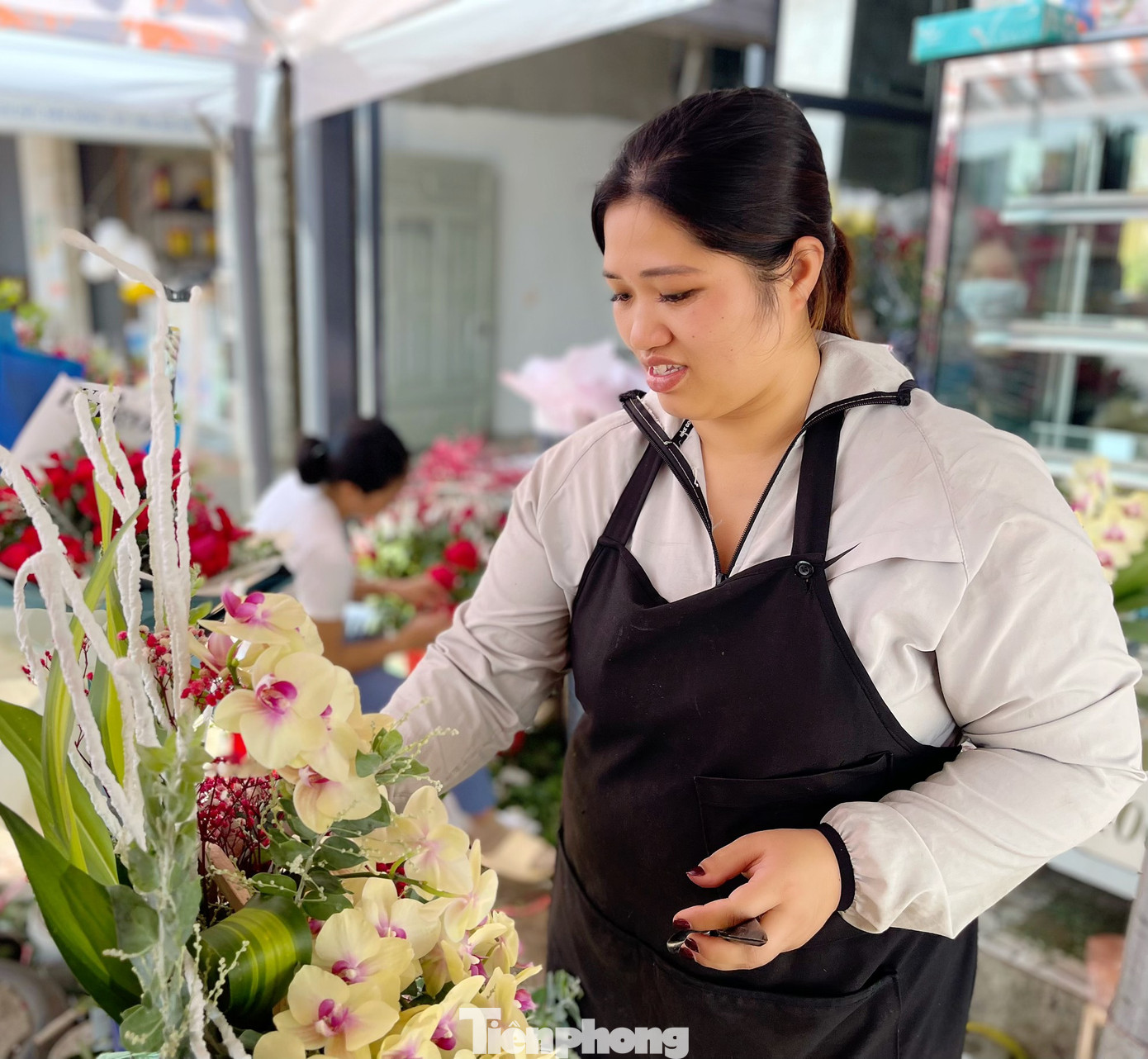 Chị Nguyễn Thị Tuyết Mai cắm hoa tươi cho khách đặt tại cửa hàng