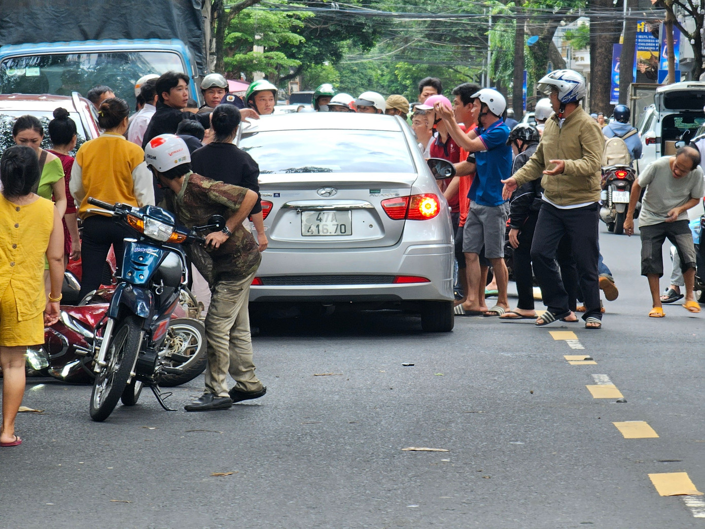Người dân tập trung đưa nạn nhân ra khỏi ô tô để đi cấp cứu.
