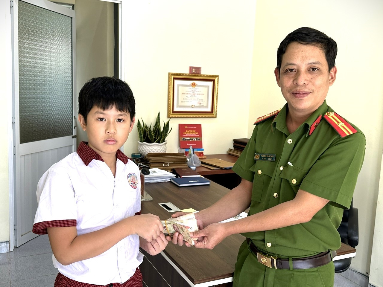 Em Nguyễn Ngọc Vũ trao số tiền nhặt được cho công an Em Nguyễn Ngọc Vũ trao số tiền nhặt được cho công an