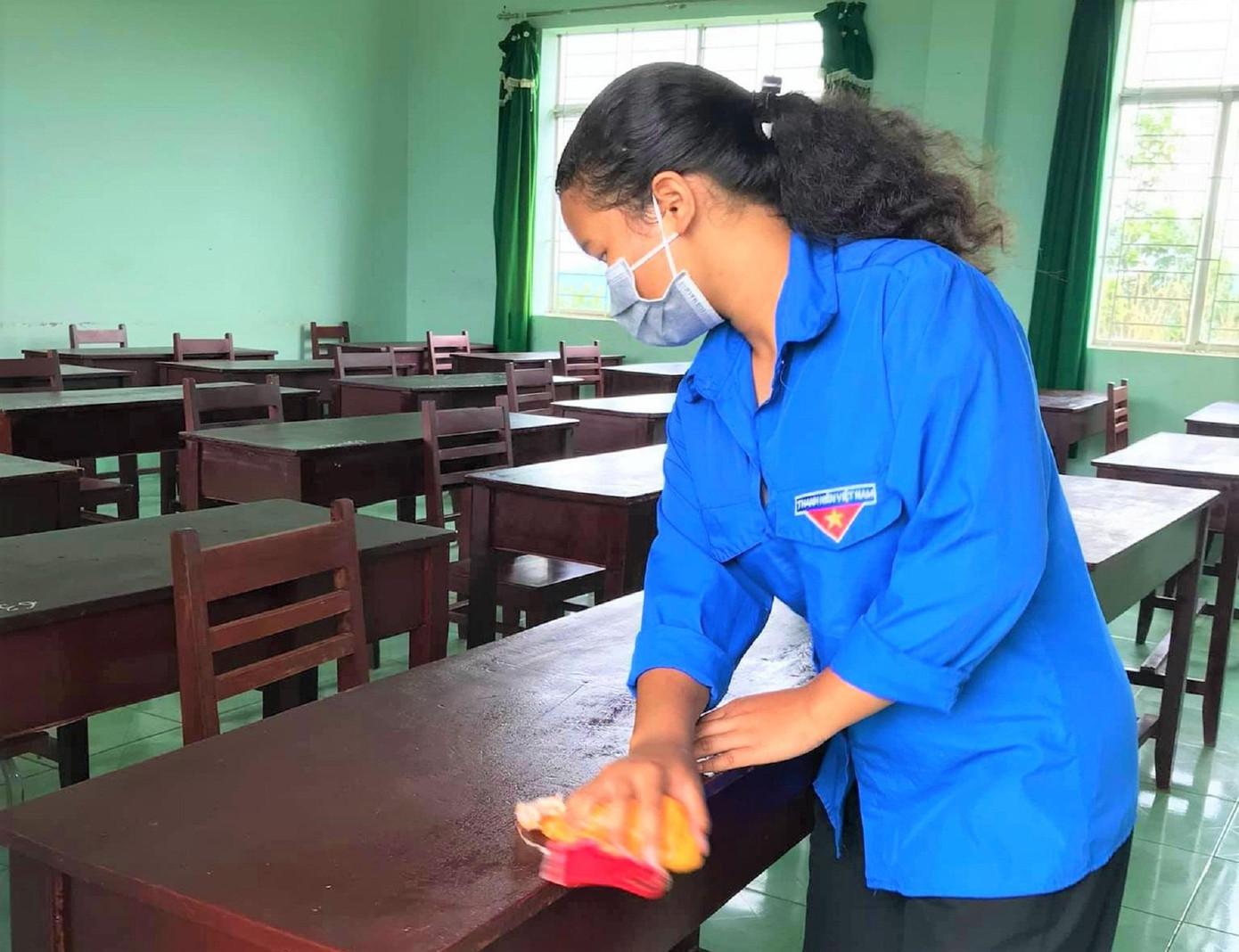 Tình nguyện viên lau bàn ghế trong phòng dự thi cho thật tươm tất Tình nguyện viên lau bàn ghế trong phòng dự thi cho thật tươm tất