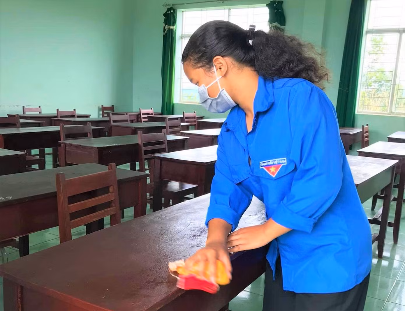 Tình nguyện viên lau bàn ghế trong phòng dự thi cho thật tươm tất Tình nguyện viên lau bàn ghế trong phòng dự thi cho thật tươm tất