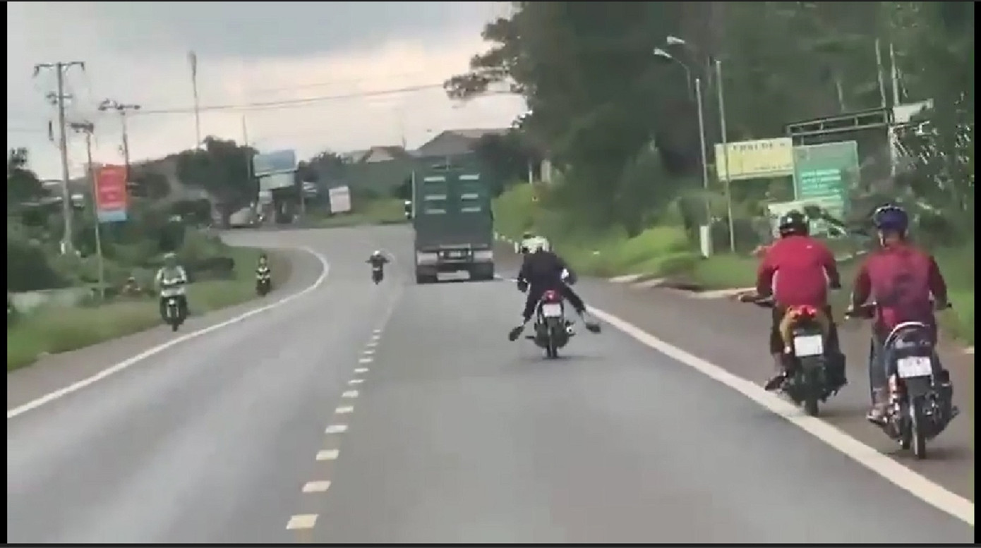 Hình ảnh nam thanh niên nằm úp khi chạy xe máy trên đường