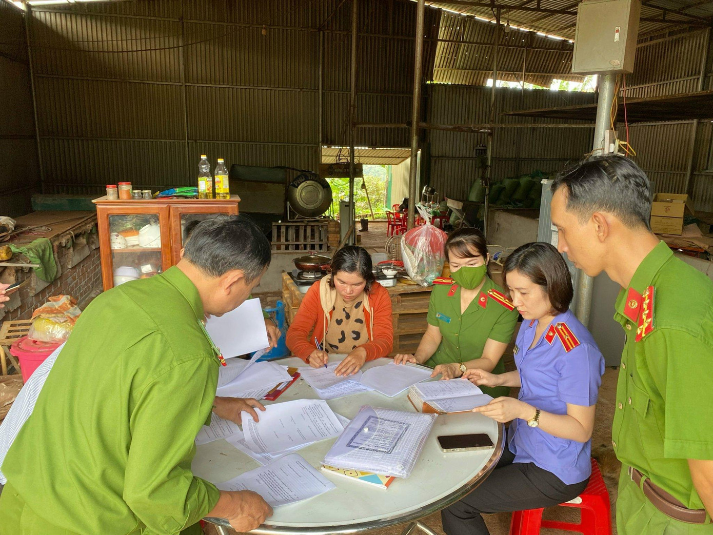 Cơ quan thi hành pháp luật tống đạt các quyết định khởi tố đối với bà Kiều (áo nâu)