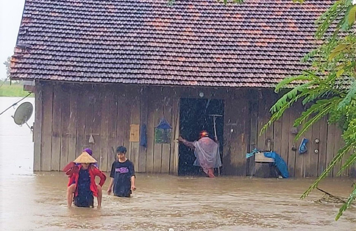 Nhà bị ngập, người dân di chuyển ra nơi an toàn. Ảnh B.Bân