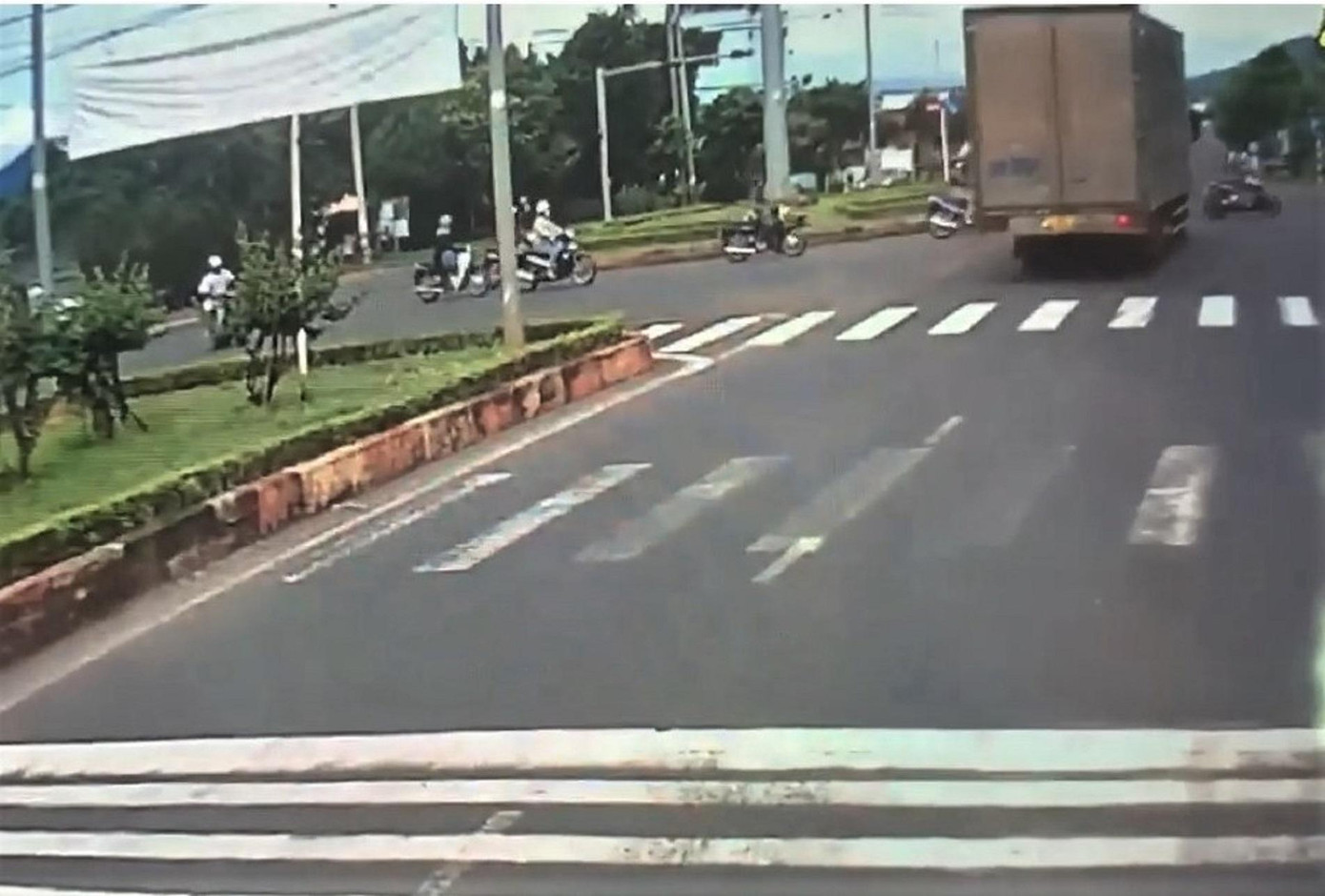 Hình ảnh chiếc xe tải vượt đèn đỏ, vượt qua dòng xe máy. Ảnh cắt clip