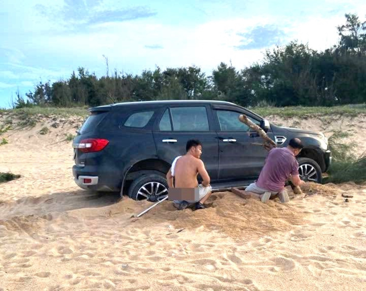 Chiếc ô tô bị mắc kẹt trong cát sau khi chạy vào bãi biển. Chiếc ô tô bị mắc kẹt trong cát sau khi chạy vào bãi biển.