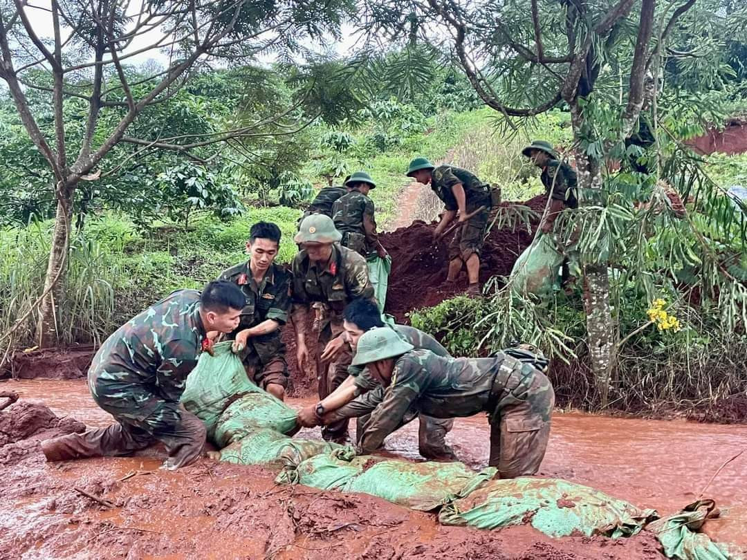 Lực lượng vũ trang đắp bao đất ngăn không cho đất trôi vào hoa màu, đường giao thông...
