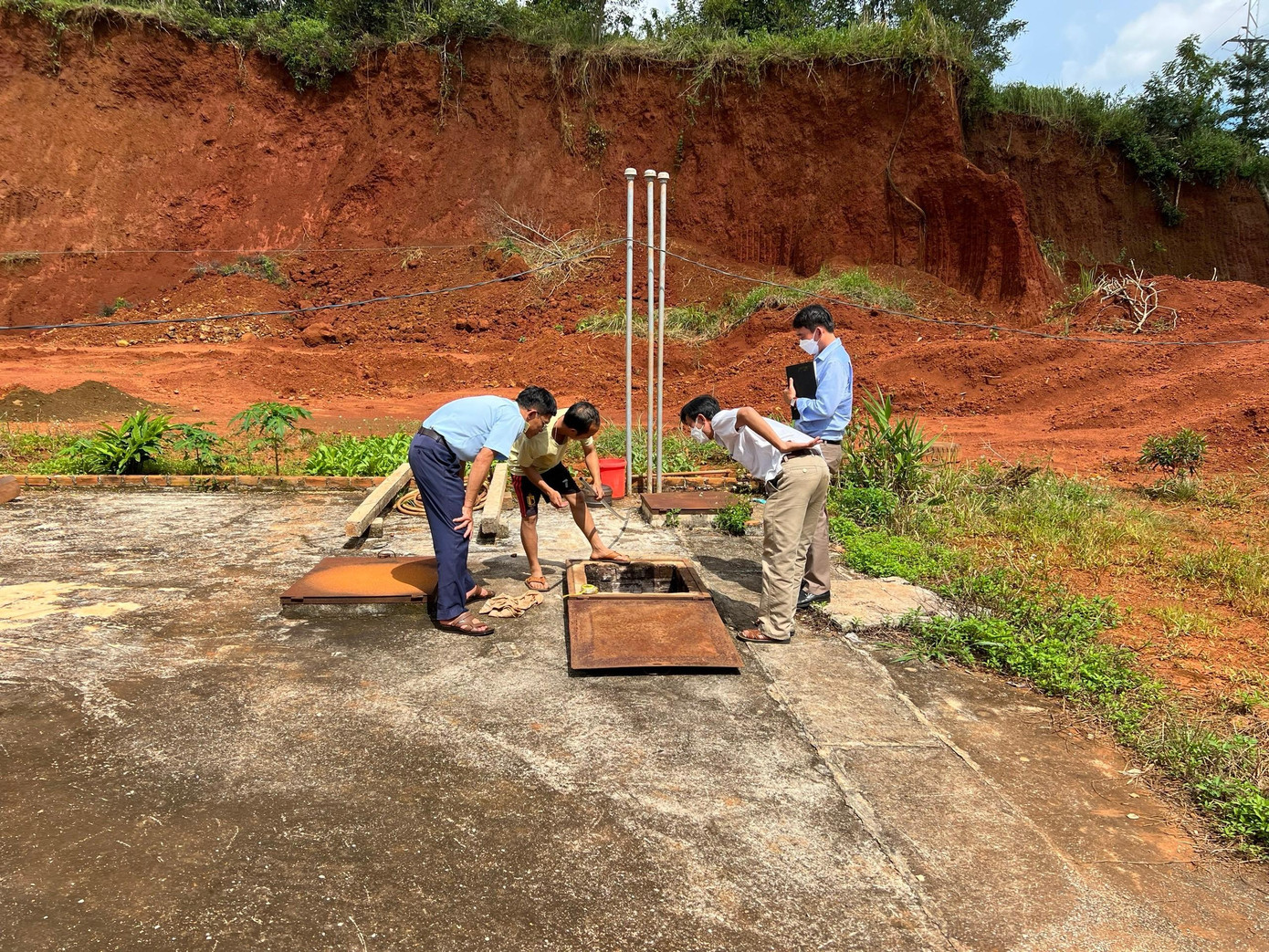 Đoàn kiểm tra bồn chứa xăng dầu của một cửa hàng Đoàn kiểm tra bồn chứa xăng dầu của một cửa hàng