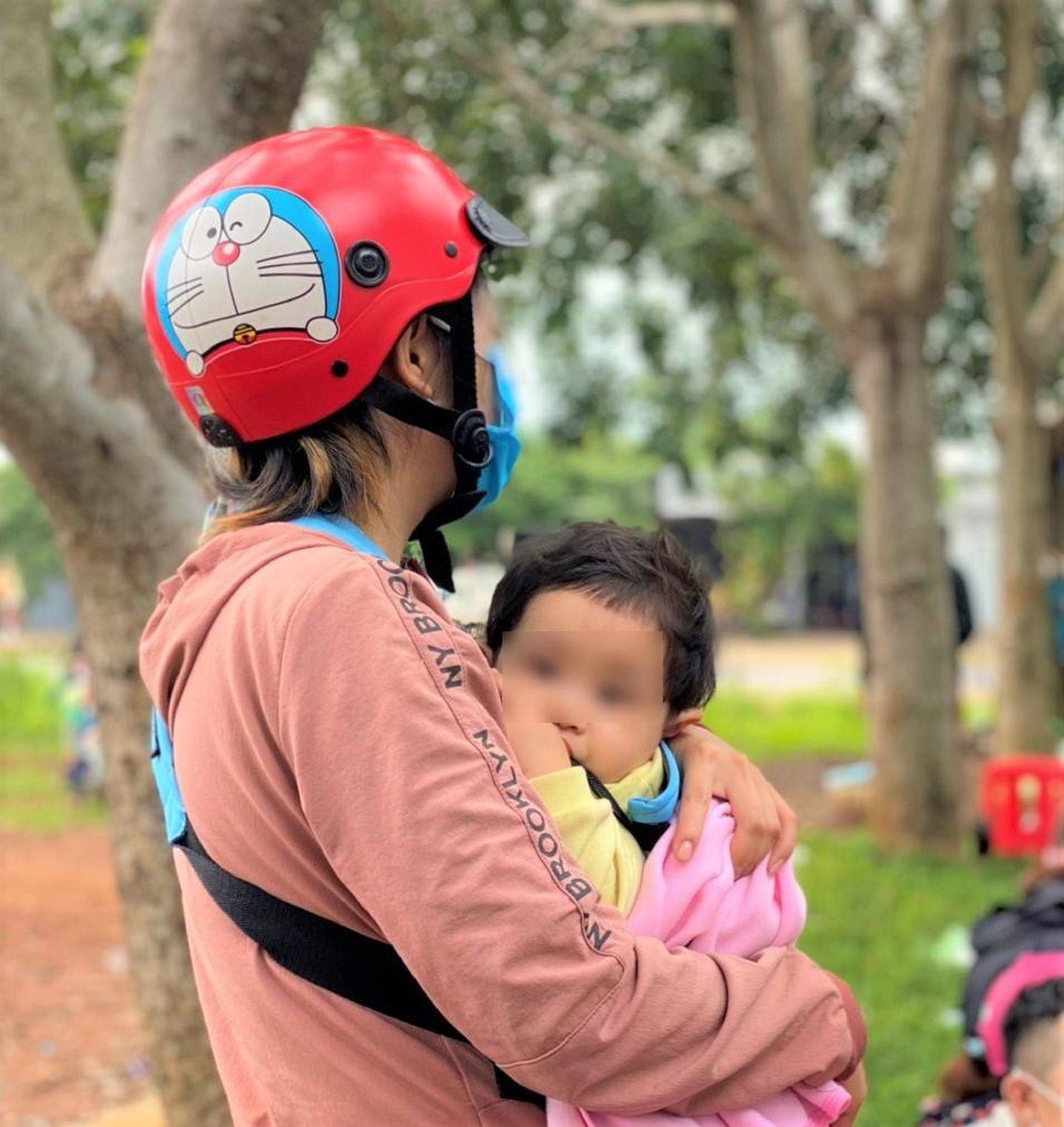 Em bé an nhiên trong vòng tay mẹ. Ảnh: T.Long