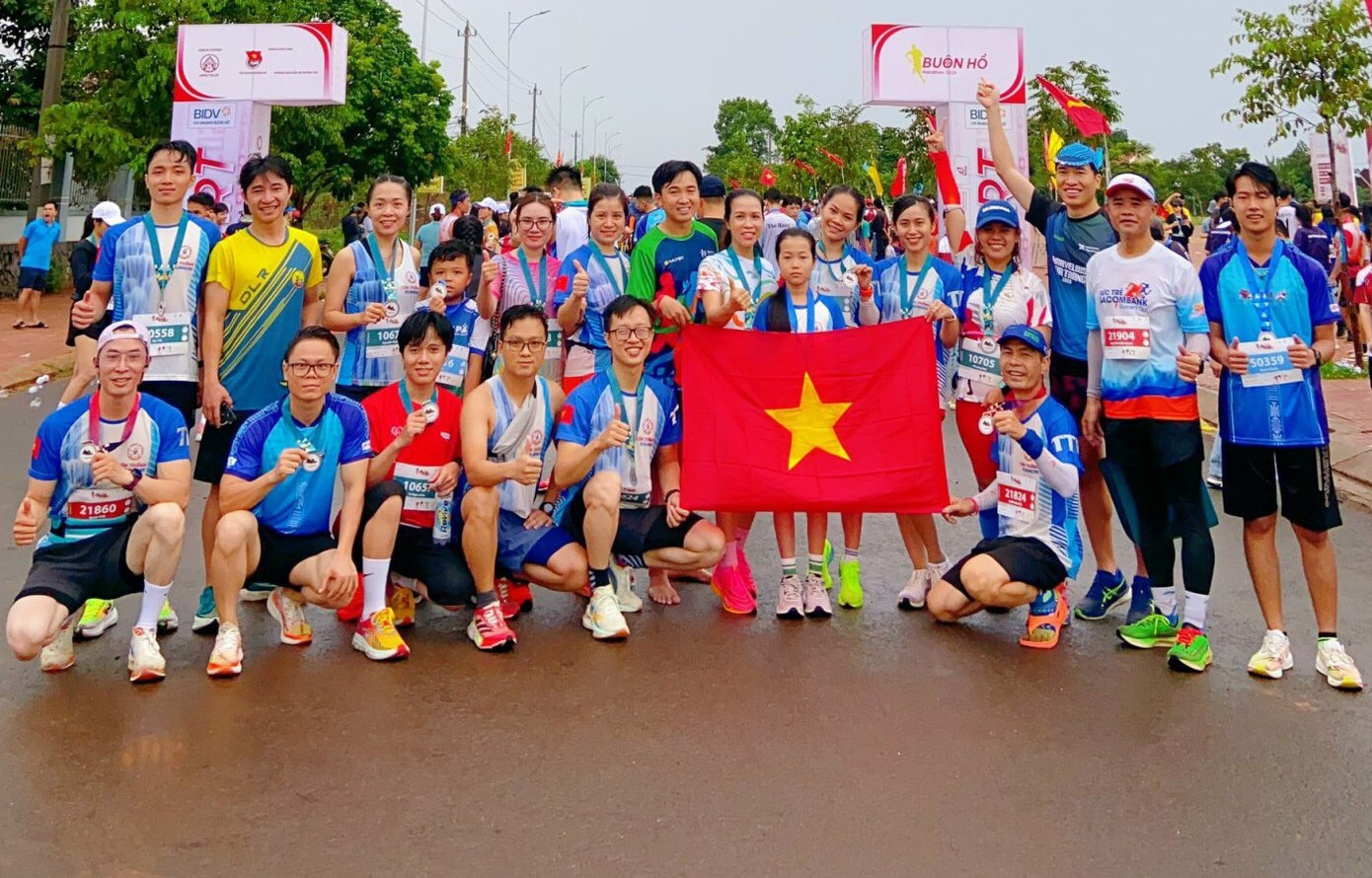 Các vận động viên chụp ảnh kỷ niệm bên lá cờ Tổ quốc