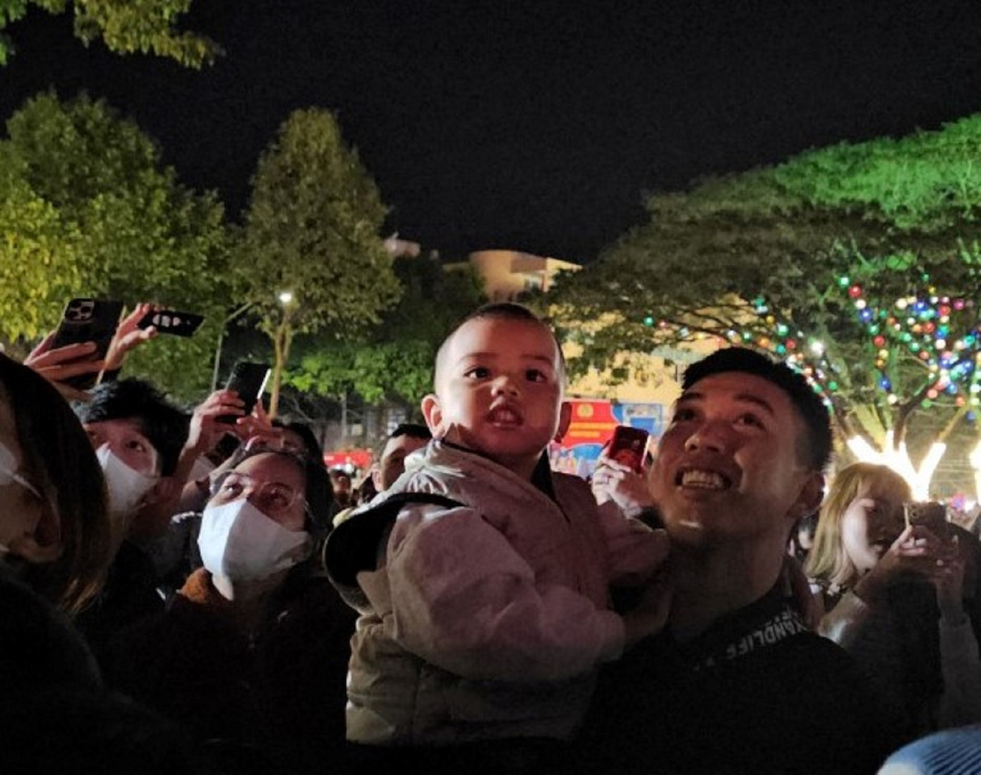 Một em bé theo gia đình đi xem pháo hoa Một em bé theo gia đình đi xem pháo hoa