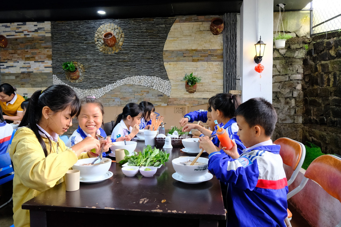 Các em học sinh vui tươi khi được thưởng thức tô phở nóng hổi Các em học sinh vui tươi khi được thưởng thức tô phở nóng hổi