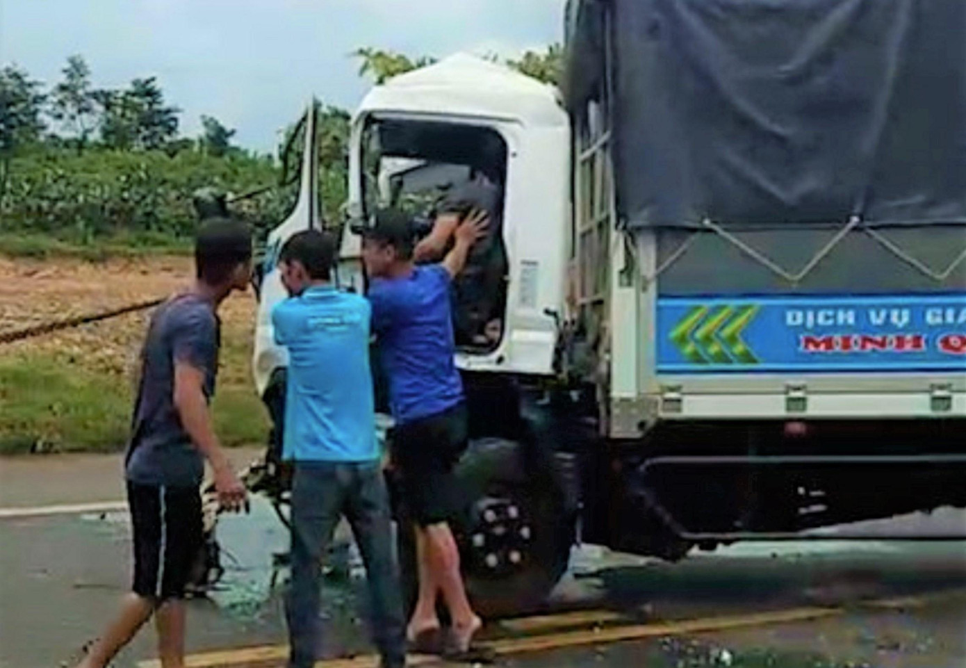 Người đi đường hỗ trợ đưa người bị kẹt trong xe ra ngoài