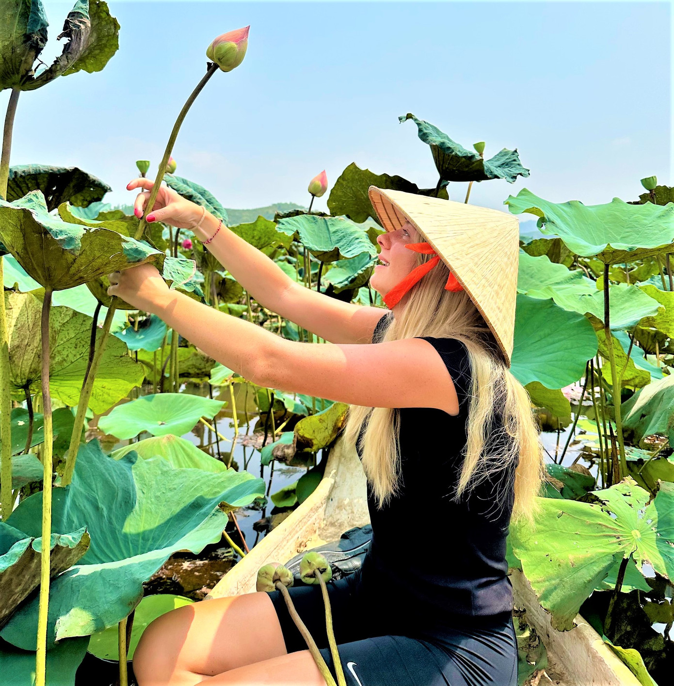 Nữ du khách nước ngoài tạo dáng bên hoa sen