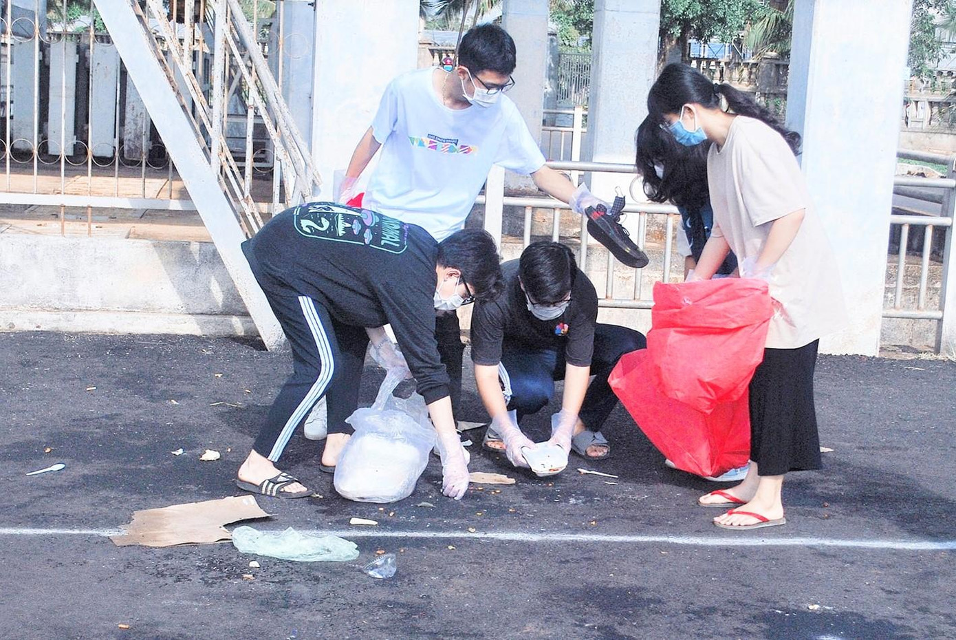 Nhóm bạn trẻ thu dọn thức ăn thừa bị bỏ giữa đường