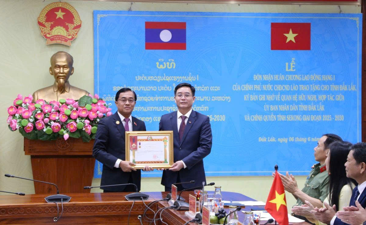 Thừa ủy quyền của Chính phủ Lào, ông Leklai Sivilay - Bí thư Tỉnh ủy, Tỉnh trưởng tỉnh Sekong (Lào) (bên trái) trao Huân chương Lao động hạng Nhất cho ông Nguyễn Đình Trung - Bí thư Tỉnh ủy Đắk Lắk.