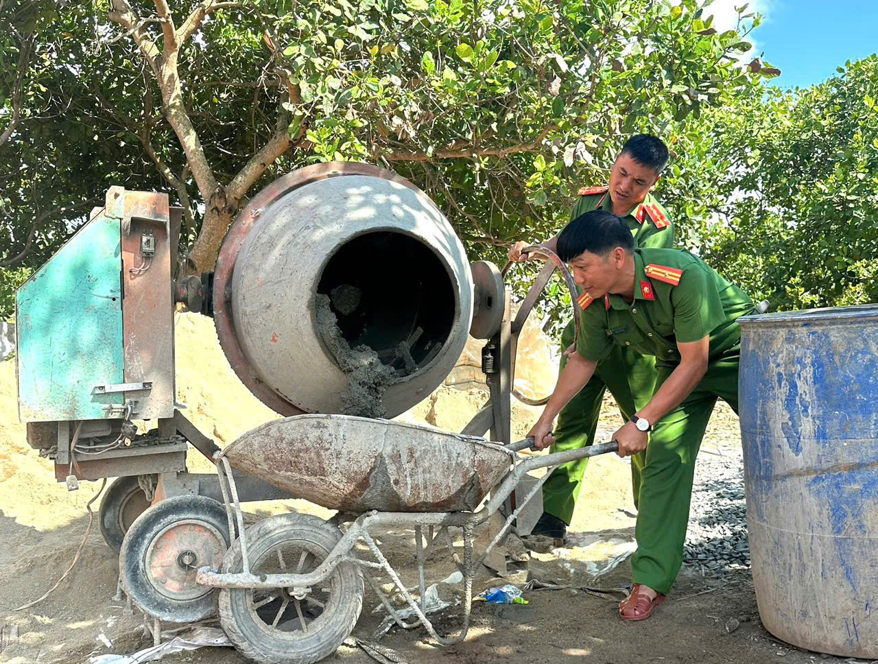 Cán bộ, chiến sĩ công an hỗ trợ xây nhà cho người dân.