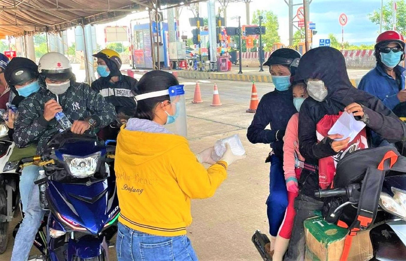 Trên đường di chuyển về Tây Nguyên, nhiều người bất ngờ khi nhận được chiếc bánh bao, ly sữa nóng hổi tại chốt kiểm soát dịch bệnh Cai Chanh (xã Đắk Ru, huyện Đắk R’lấp, Đắk Nông). Trong ảnh: Người dân cảm động khi nhận bánh bao trên đường về quê.
