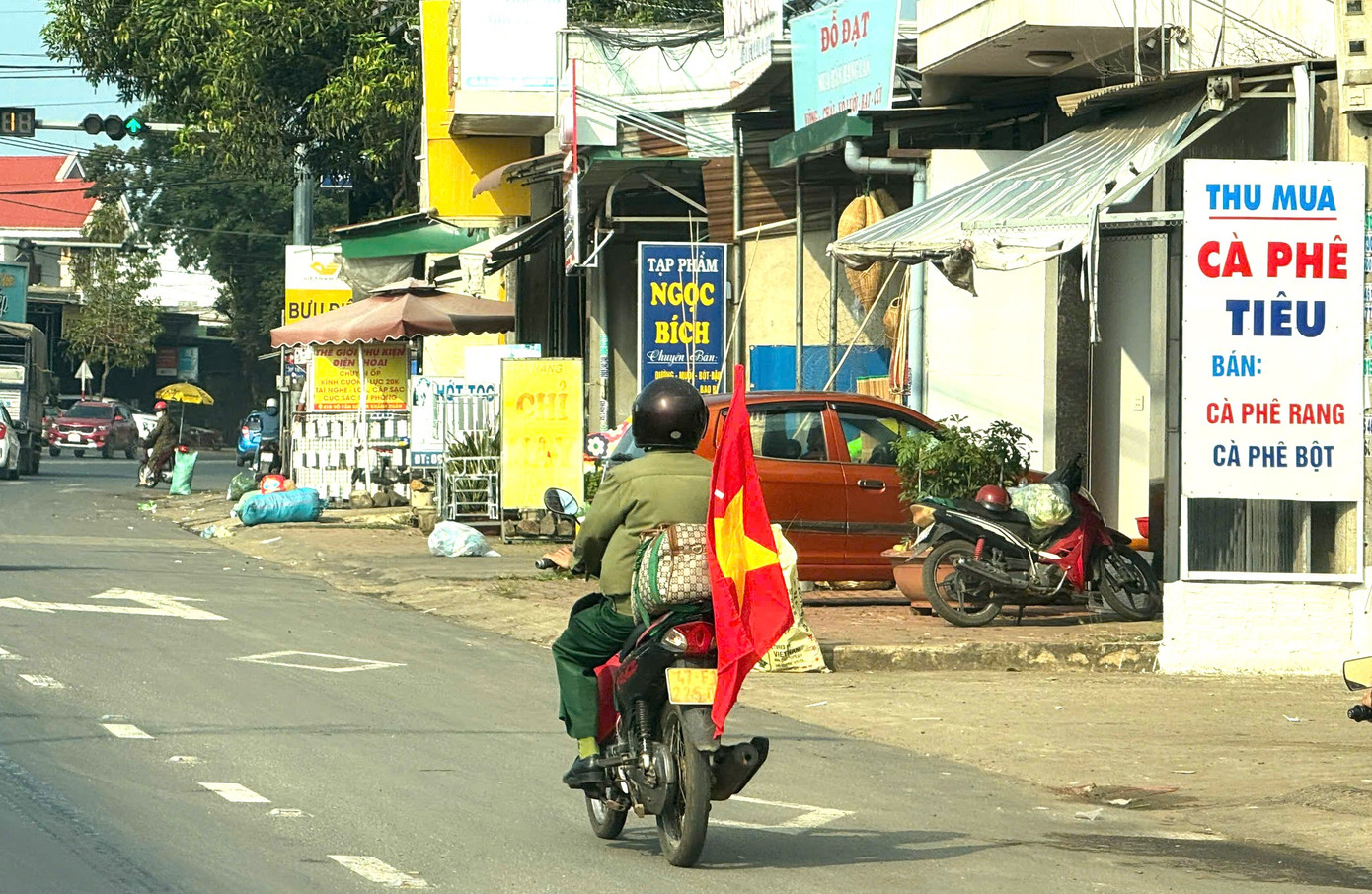 Cựu binh Tính độc hành trên chiếc xe máy quen thuộc với lá cờ đỏ sao vàng.