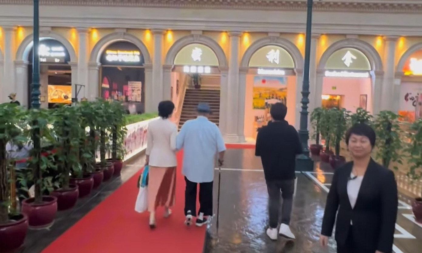 Hồng Kim Bảo và vợ sánh đôi trong chuyến đi chơi cùng đại gia đình. Ảnh cắt từ video.