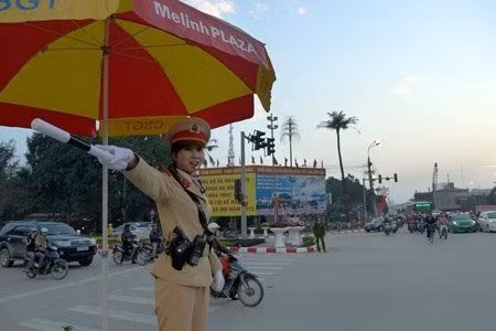 Trung sỹ Nguyễn Thị Kim Anh đứng bục điều tiết giao thông vào giờ cao điểm tại ngã tư cầu Trắng – Hà Đông