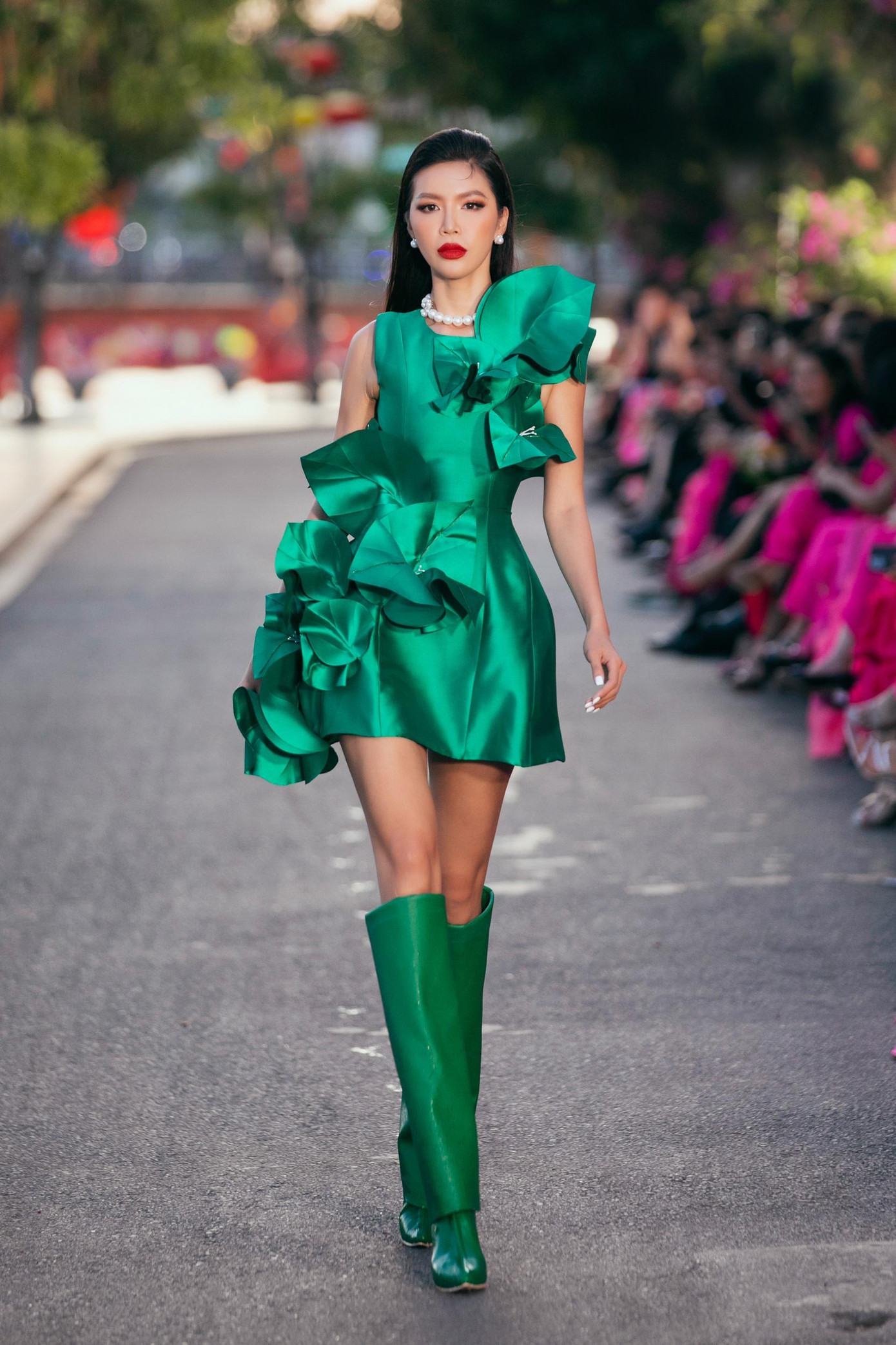 Minh Tú diện bộ váy xanh có thiết kế lạ mắt khi sải bước với vai trò vedette.